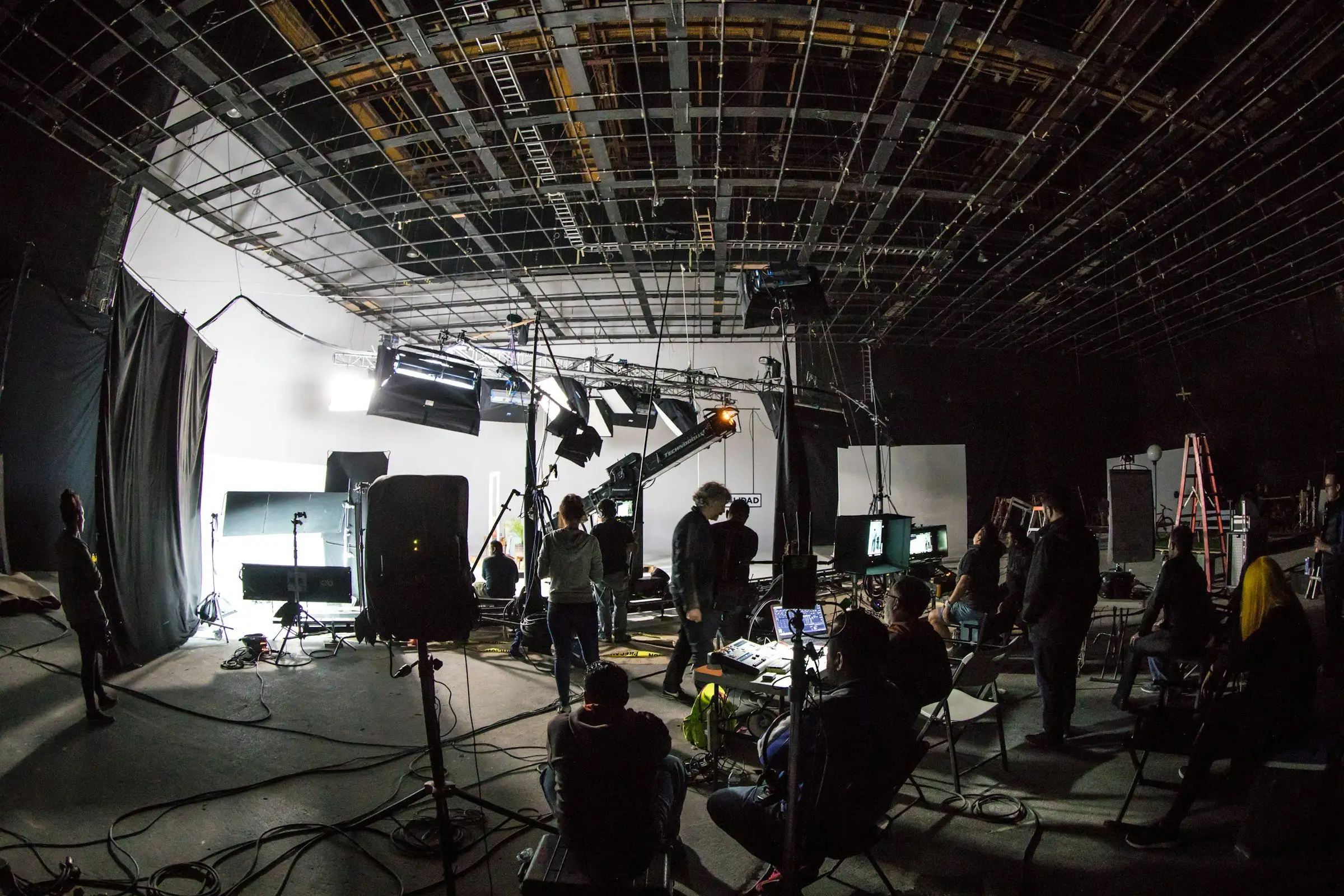 Crew at work across a large soundstage under the lighting grid